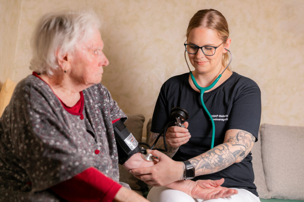 Krankenschwester in der häuslichen Pflege beim Blutdruck messen